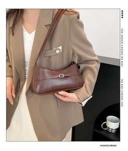 Detail view of the vintage dark brown baguette bag with a silver buckle strap and glossy finish