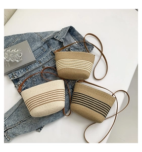 Detailed top view of three straw bucket bags in striped patterns on denim jacket