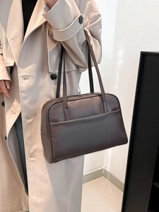 Minimalist large brown leather tote bag for women worn by model in beige trench coat