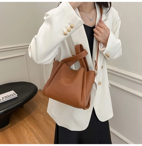 Detail of a brown lychee pattern leather bucket bag with unique knotted handle design