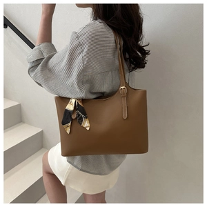 Brown leather tote bag detail with stylish printed silk scarf on the shoulder strap