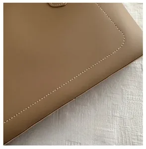 Close-up of tan leather tote bag showing clean white stitching and premium texture