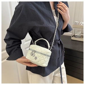 Vue détaillée d'un mini sac à bandoulière blanc matelassé avec breloque fleur et chaîne argent
