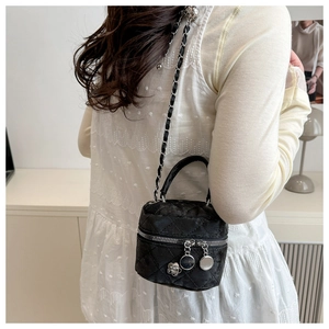 Détail du mini sac matelassé avec pendentif camélia et bandoulière en chaîne