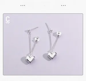 Détail de boucles d'oreilles cœur en argent S925 avec chaînes et fermoirs papillon