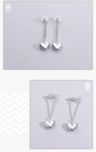 Détail de boucles d'oreilles cœur argentées avec chaînes pendantes et fini poli