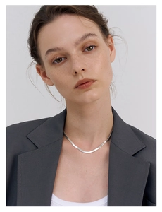 Detailed view of elegant silver S925 flat snake bone chain necklace on a model's collarbone