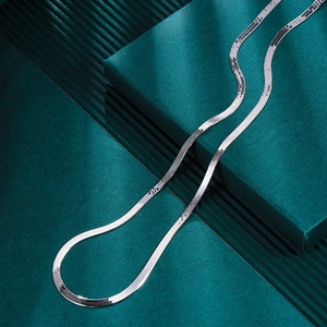 Macro shot of silver S925 flat snake chain showing smooth mirror finish on dark backdrop