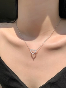 Creative shadow of a sterling silver heart pendant with sparkling crystals on neck