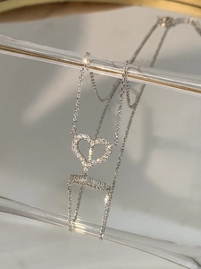 Macro shot of silver heart pendant with shimmering pavé cubic zirconia and mirror reflection