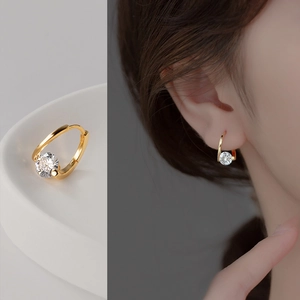 Detail of s925 gold silver hoop earrings with a round white zircon worn by a model