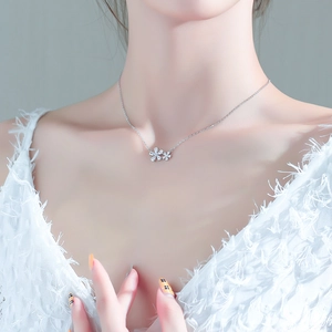 Close-up of elegant silver floral pendant necklace with sparkling zircon crystals on neck
