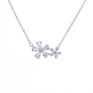 Close-up of elegant flower pendant with clear zircon petals on a silver chain