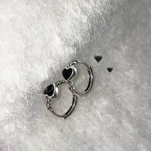 S925 sterling silver hoop earrings with vintage black heart charms on faux fur background
