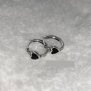 Close-up of S925 silver vintage hoop earrings with black enamel heart and twisted texture