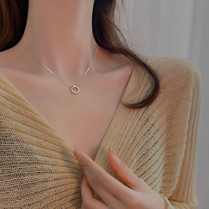 Close-up of a 925 sterling silver star ring pendant necklace worn on a warm sweater