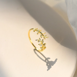Elegant gold leaf ring with sparkling cubic zirconia stones and adjustable open band design