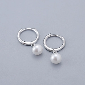 Close-up of minimalist silver pearl drop earrings with high-gloss white pearls