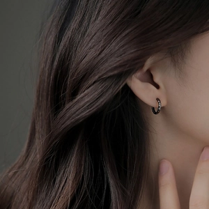 Minimalist black geometric rhodium faceted hoop earring worn by female model
