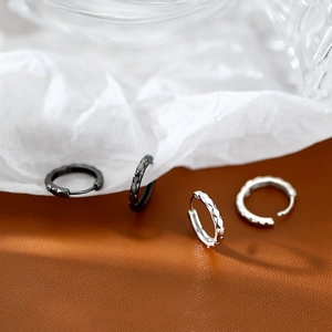 Minimalist geometric faceted hoop earrings in black and silver with a textured finish