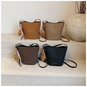 Detailansicht der Vintage-Beuteltaschen in vier Farben mit Bärenanhängern und Schals