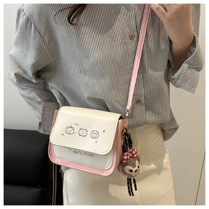 Detail of pink and white crossbody bag with cute cartoon bears and plush charm