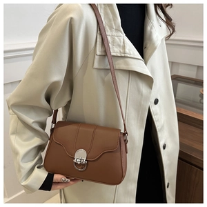 Close-up of vintage brown leather handbag with elegant silver metal ring lock detail