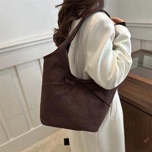 Sac hobo minimaliste en cuir mat marron foncé avec un nœud décoratif sur l'épaule