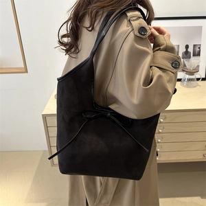 Grand sac cabas noir mat rétro avec nœud porté par un mannequin en trench-coat