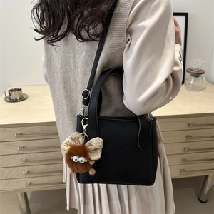 Sac seau chic en cuir noir à motif litchi avec un charmant pendentif en peluche marron