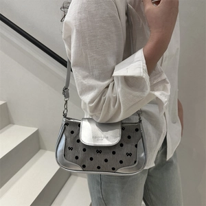 Chic silver grey underarm bag with polka dots and bow embroidery shown on a model