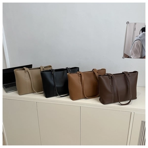 Detail of four colorful tote bags with white contrast stitching on a minimalist shelf