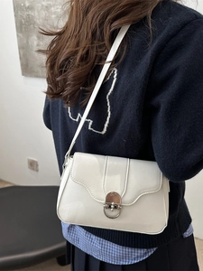 Chic beige patent leather baguette bag with wavy flap design and silver ring buckle