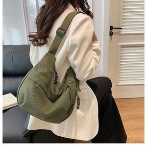 Dark green corduroy crossbody bag with adjustable wide strap and multi-pocket design