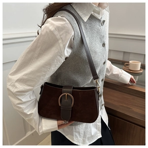 Detail einer dunkelbraunen matten Wildleder-Achseltasche mit großer Vintage-Metallschnalle