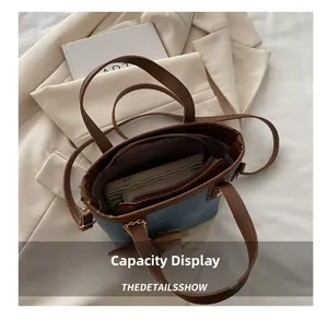 Detail shot of the spacious blue denim bag interior with brown leather handles and pockets
