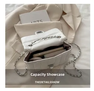 Interior capacity of white quilted chain bag showing phone and essentials