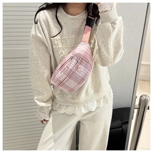 Detailed view of pink plaid crossbody bag with nylon strap and secure buckle closure