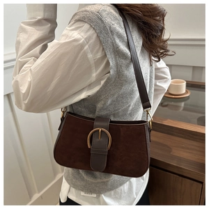 Details einer braunen Wildledertasche mit Textur und großer goldener Rundschnalle im Vintage-Stil