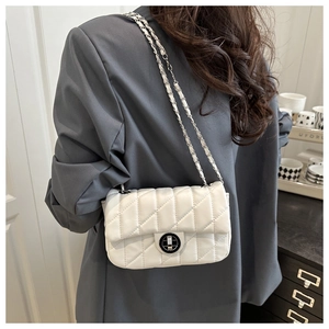 White quilted crossbody bag with silver chain strap and metal swivel lock on a model