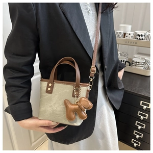 Detailaufnahme der Canvas-Beuteltasche mit Lederbesatz und braunem Welpen-Anhänger