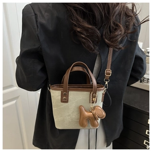 Detailansicht einer Mini-Eimertasche aus Canvas mit Lederbesatz und Hundeanhänger