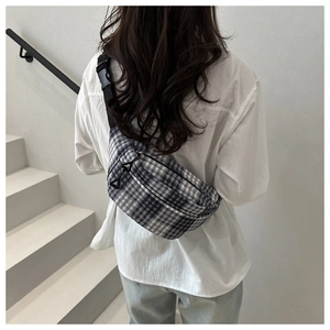 Rear view of a minimalist black and white checkered canvas fanny pack on a model