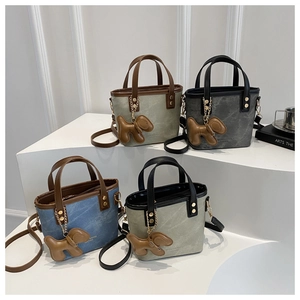Detailed view of structured mini bucket bags in assorted colors with dog charms