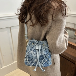 Chic quilted denim bucket bag with frayed edges and drawstring closure for women