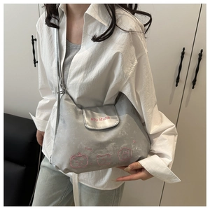 Detail der silbernen Metallic-Tasche mit rosa AITU STUDIO Logo und Bären-Aufdruck