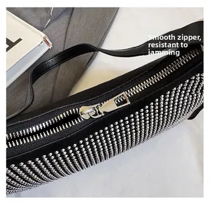 Details des glatten Silberreißverschlusses und der Metallnieten auf der schwarzen Ledertasche