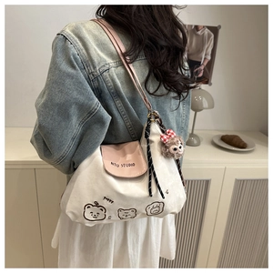 Detailaufnahme einer weißen Canvas-Tragetasche mit rosa Riemen und süßer Bären-Stickerei