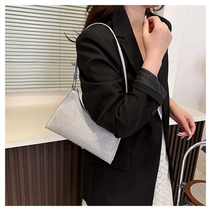 Detailaufnahme der glitzernden silbernen Strass-Baguette-Tasche, getragen zum schwarzen Blazer