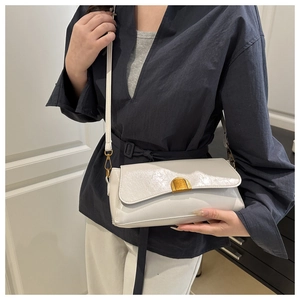 Détail du sac à bandoulière blanc ivoire brillant avec fermoir doré vintage